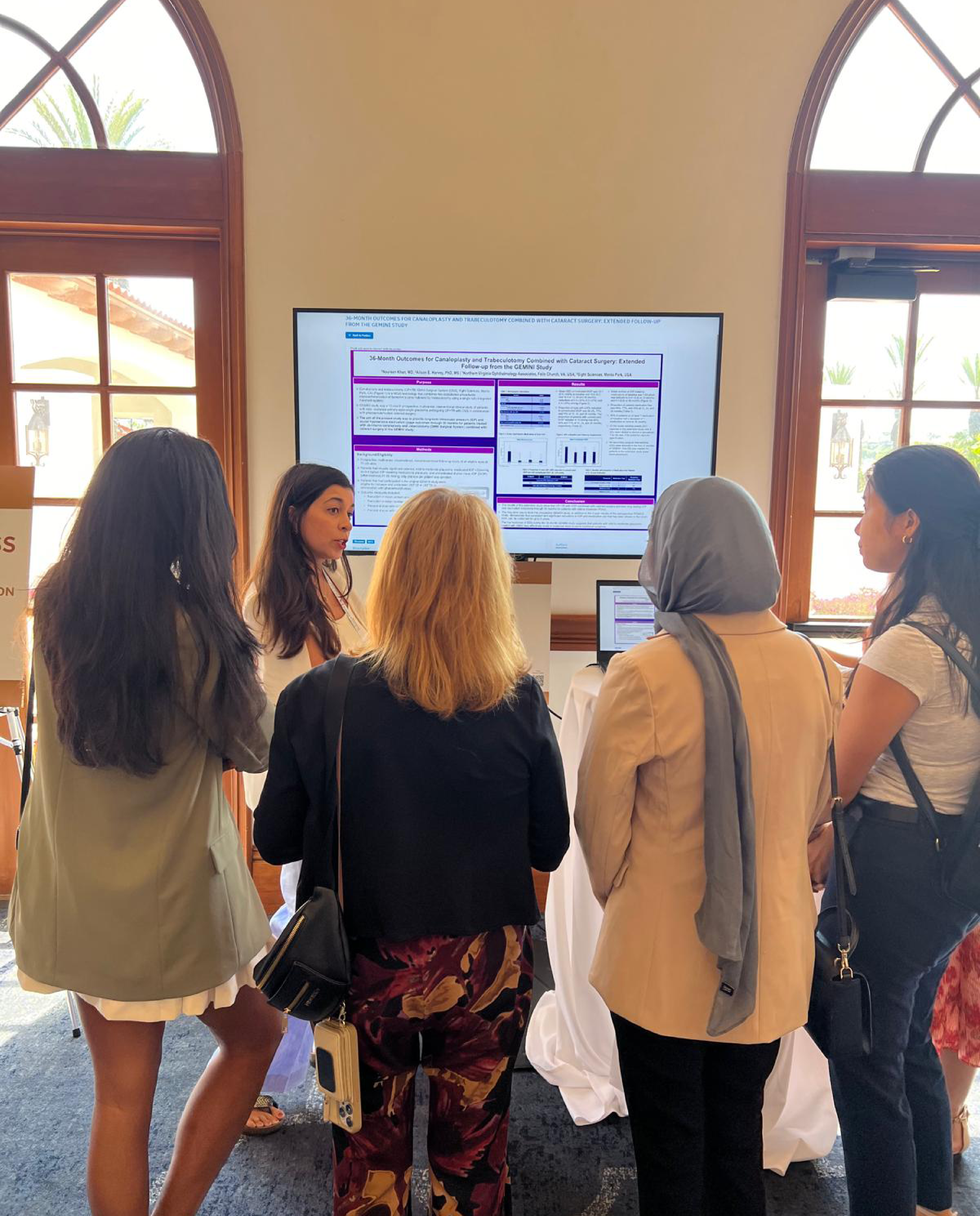 A group of women looking at a presentation on the wall while a speaker presents